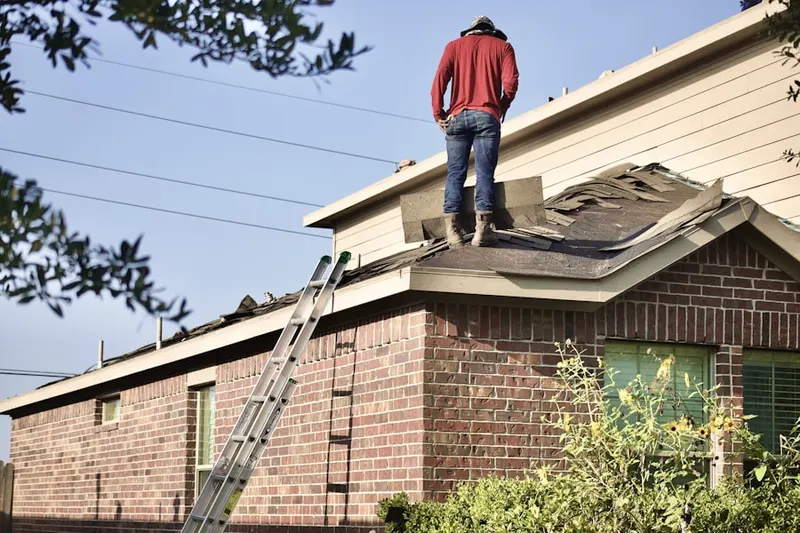 Professional roofer working on a residential roof in Raintree Gardens